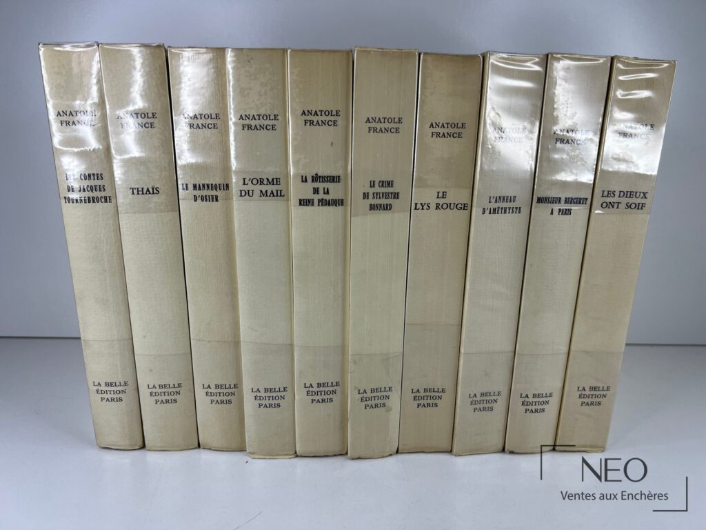 Dix volumes reliés d'Anatole France présentés de dos sous papier cristal