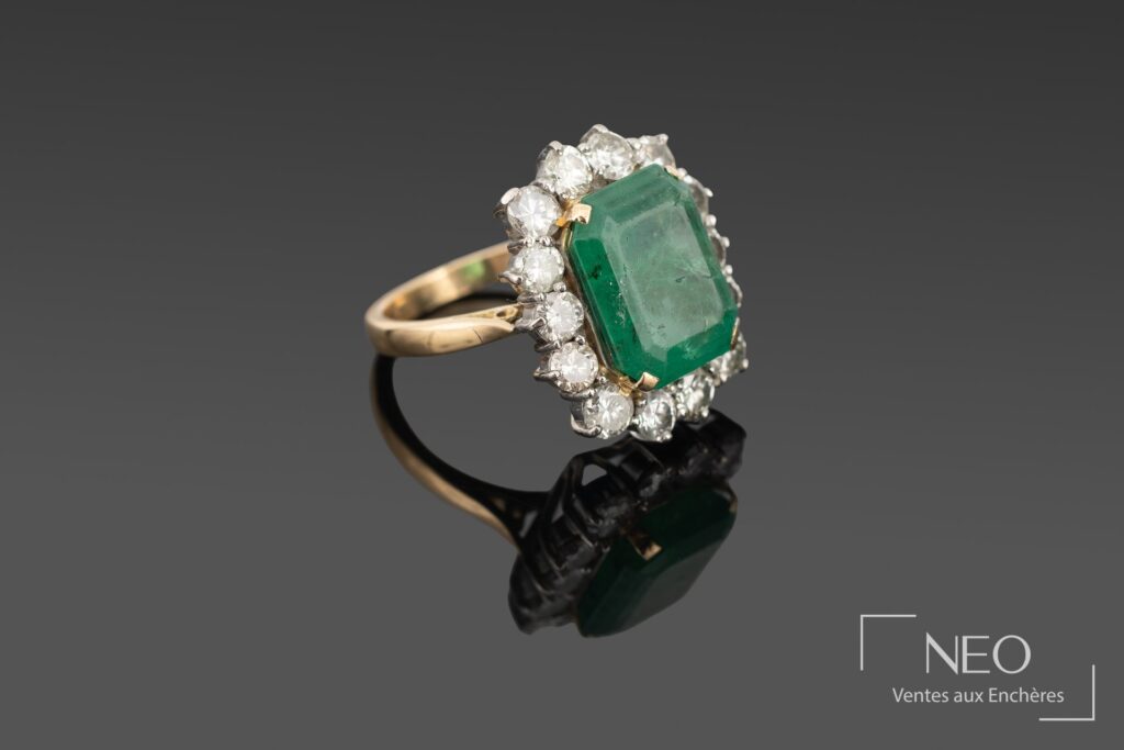 Bague en or jaune et or blanc avec émeraude rectangulaire et entourage de diamants