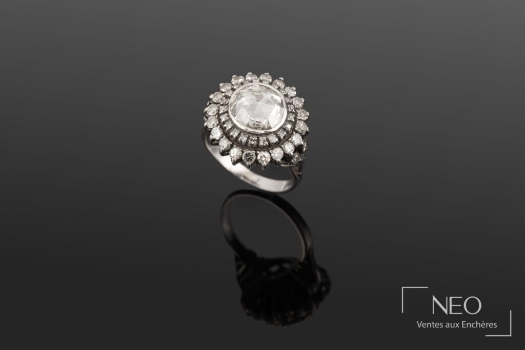 Bague en or blanc sertie d’un diamant central entouré de diamants brillants