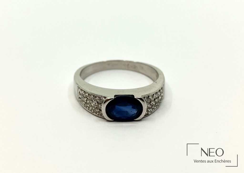 Bague en or gris sertie d’un saphir ovale bleu et de brillants sur les côtés
