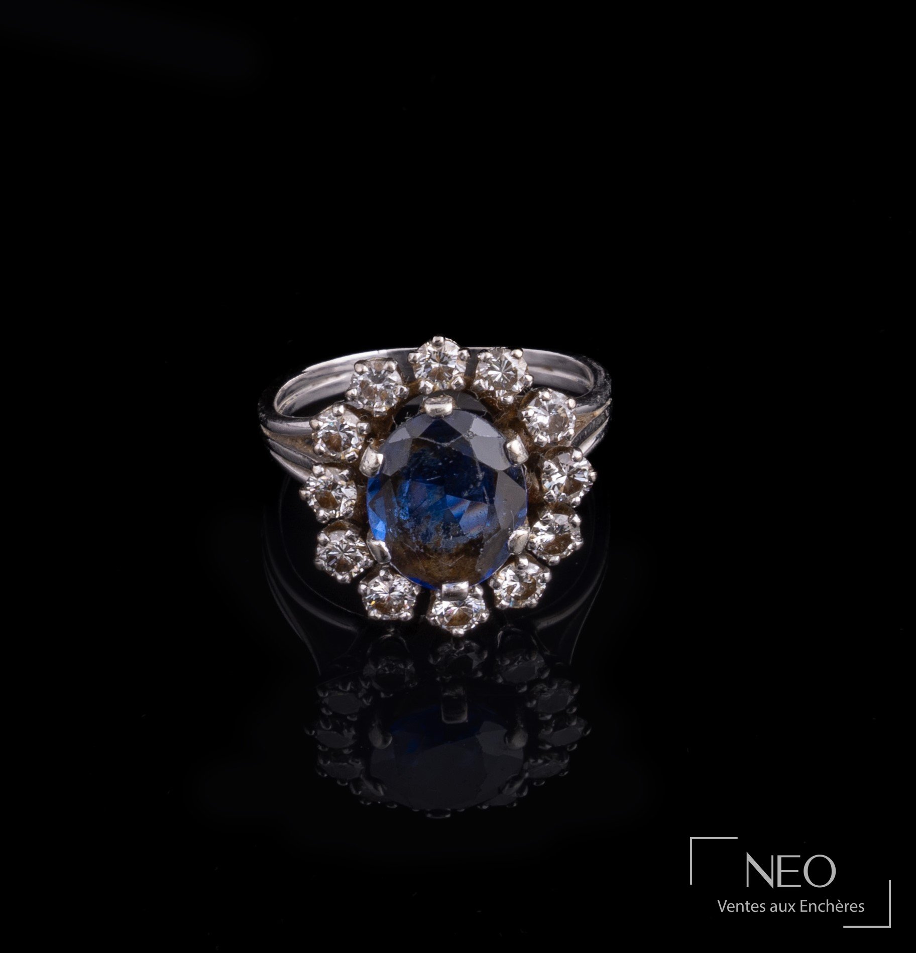 Bague marguerite en or gris avec pierre bleue centrale et entourage de diamants
