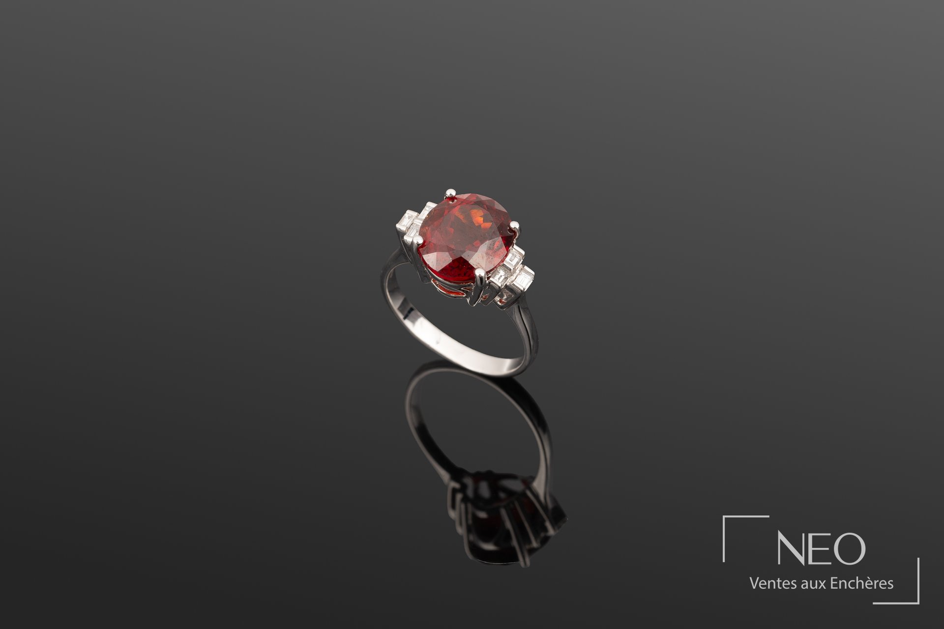 Bague en or blanc 18K sertie d’un grenat ovale et diamants