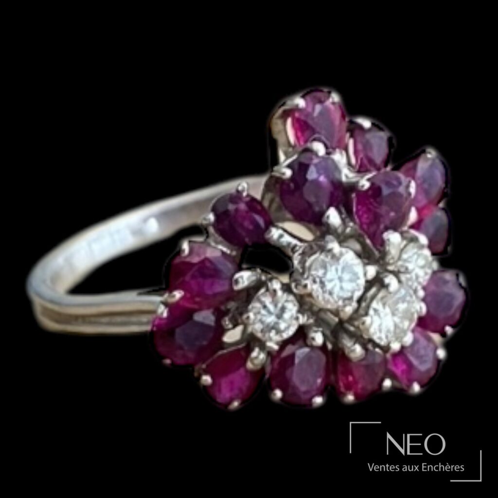 Bague en or gris sertie de grenats en bouquet et de petits diamants sur fond noir
