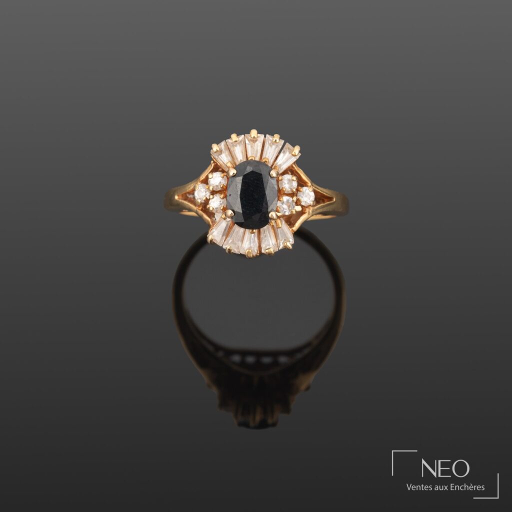 Bague en or jaune sertie d'une pierre bleue facettée entourée de pierres blanches
