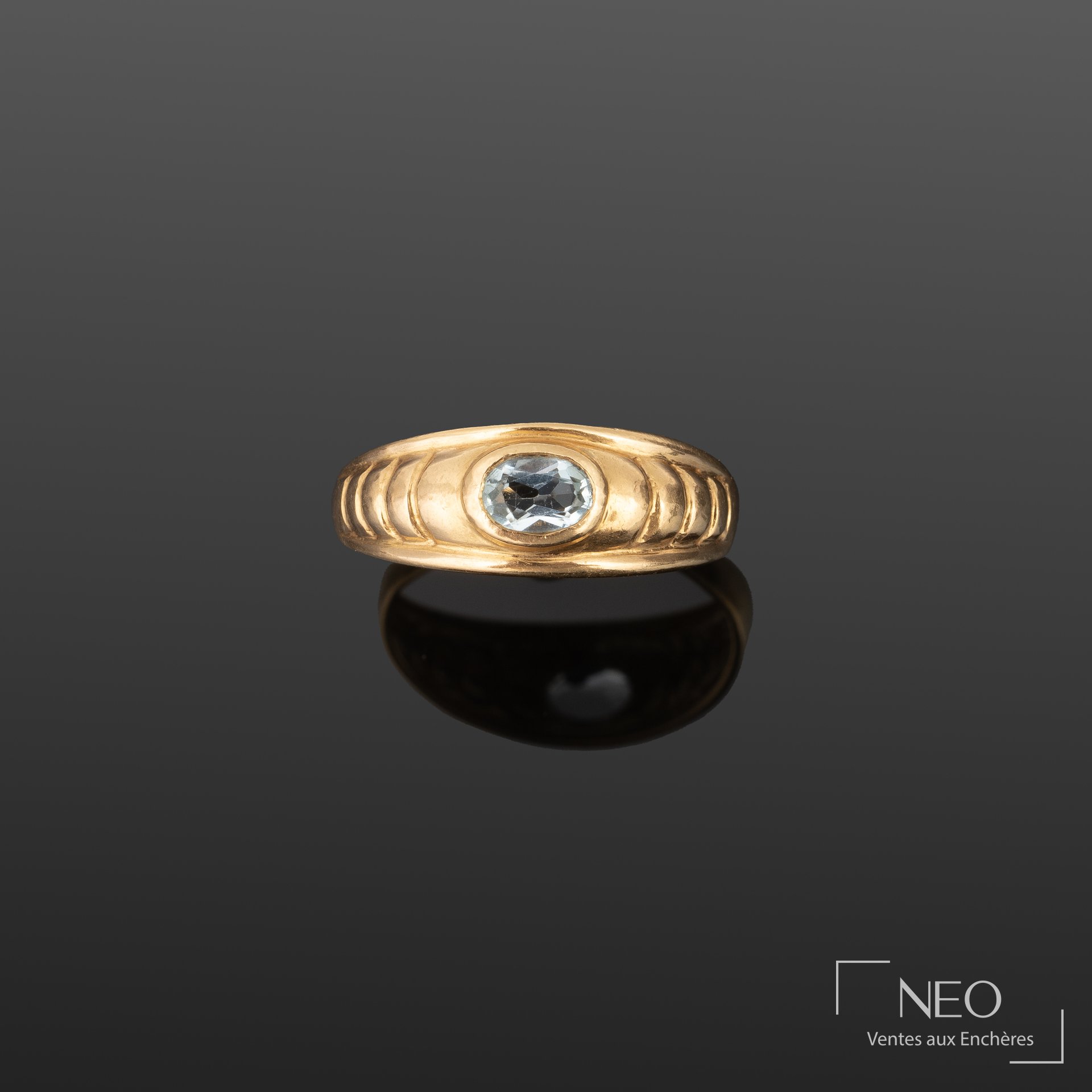 Bague en or jaune 18K, pierre bleu clair facettée en serti clos