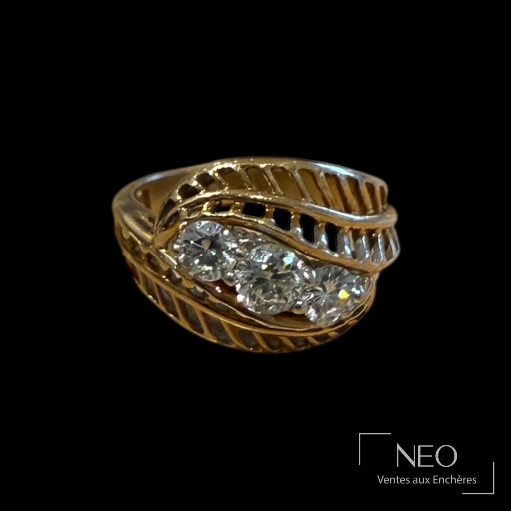 Bague en or jaune avec trois diamants sur un plateau à motif de feuilles