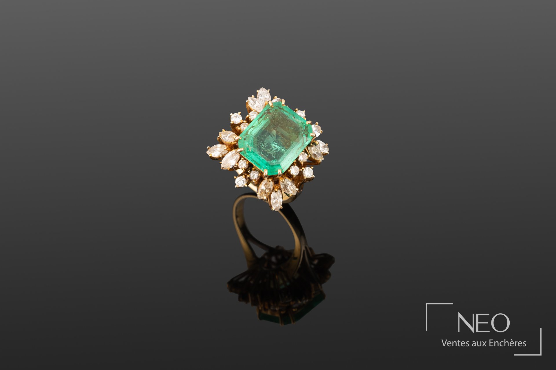 Bague en or jaune sertie d’une émeraude entourée de diamants