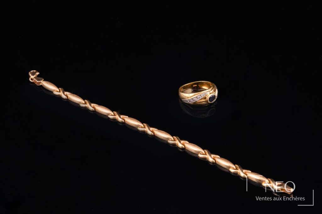 Bague en or jaune et bracelet assorti posés sur fond noir