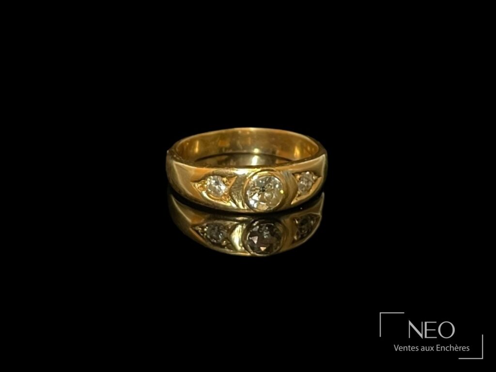 Bague ruban en or jaune ornée de trois diamants en serti clos