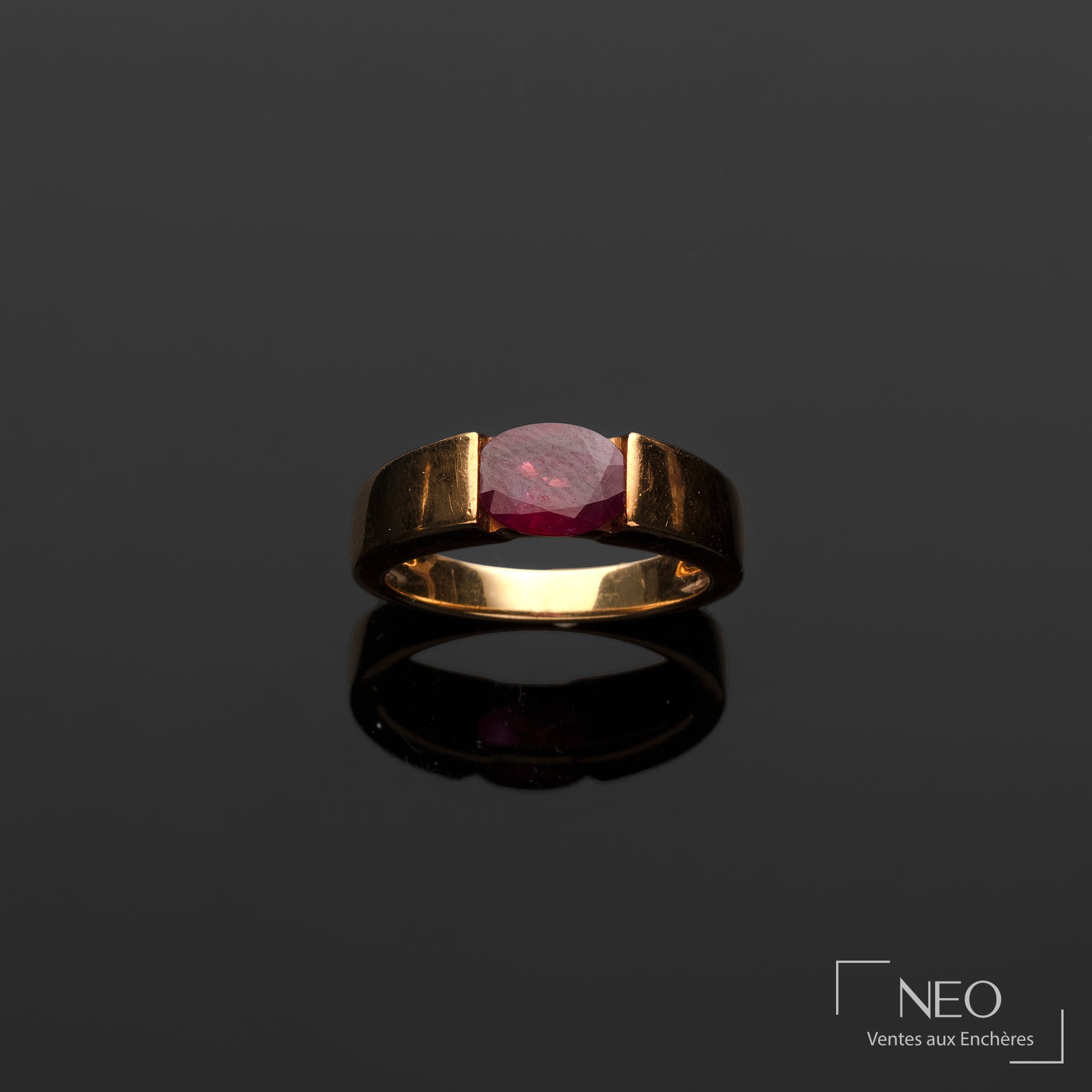 Bague ruban en or jaune 18 carats centrée d&rsquo;un rubis taille émeraude