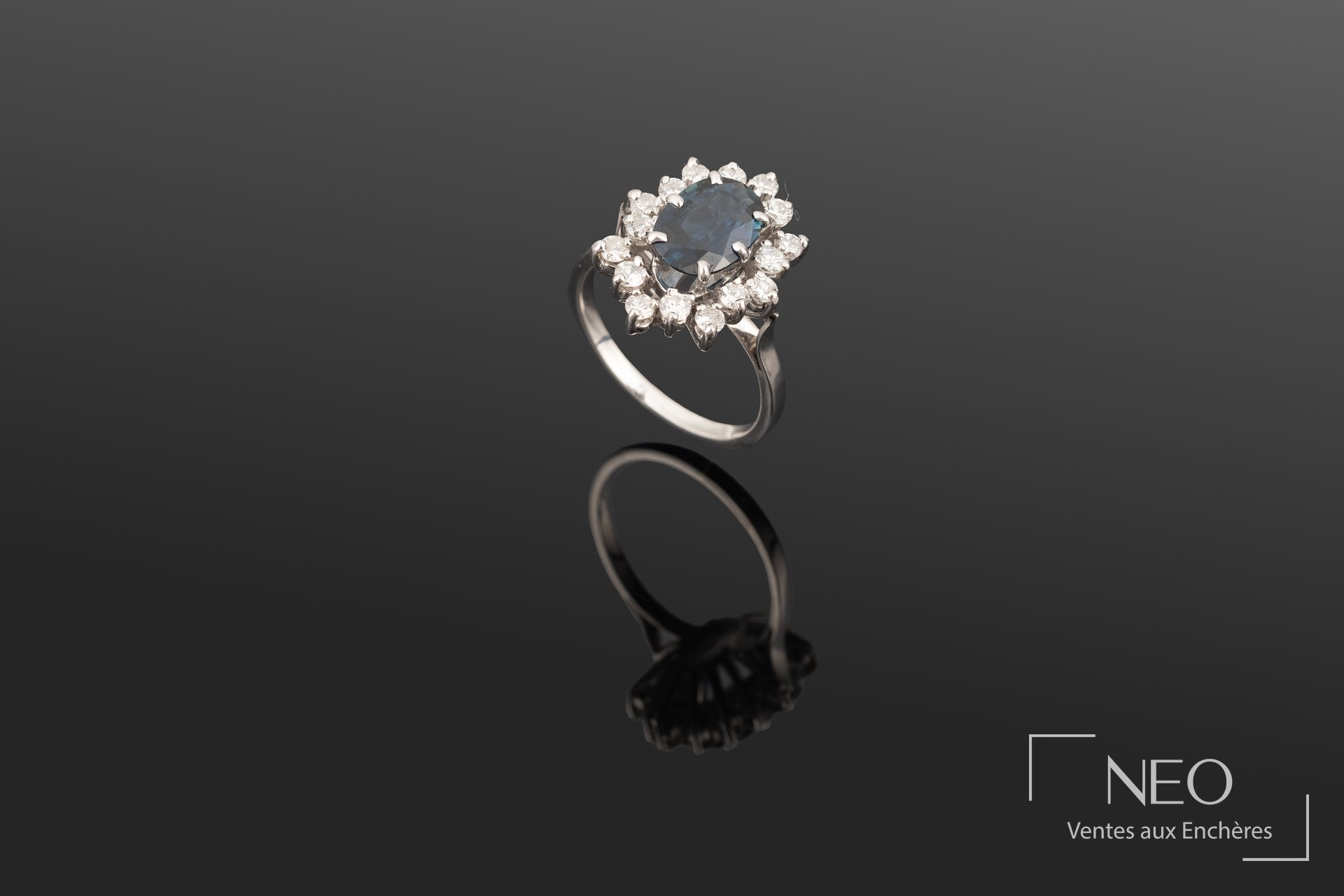 Bague en or gris 18K sertie d’un saphir et de diamants, travail français