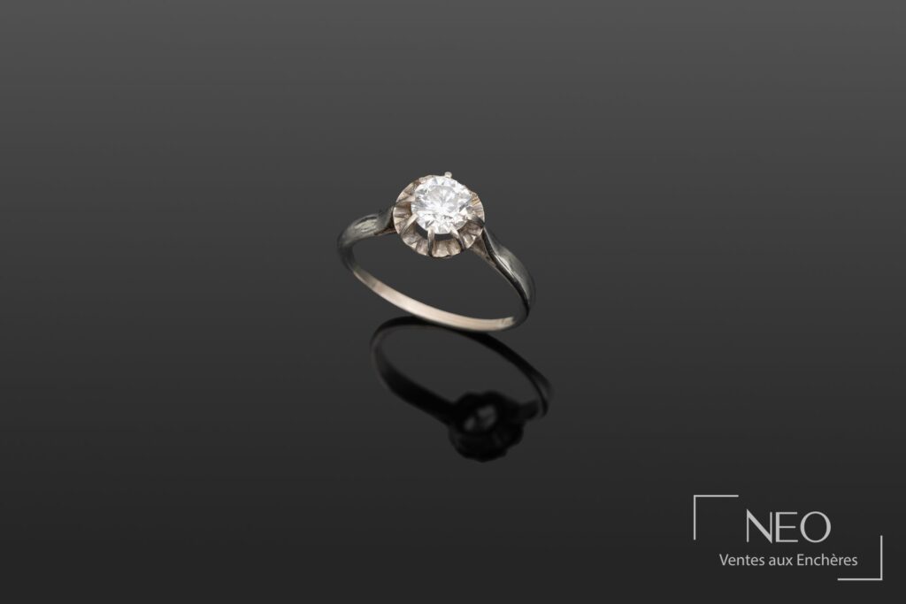 Bague solitaire en or avec diamant vu de face sur fond sombre