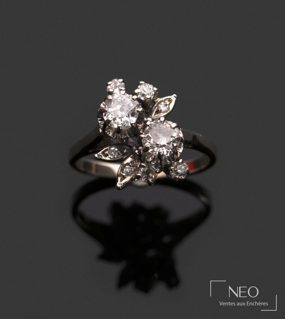 Bague toi et moi en or gris sertie de diamants sur fond noir.