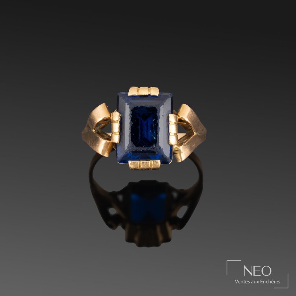 Bague en or jaune avec verre bleu rectangulaire et motifs en volutes
