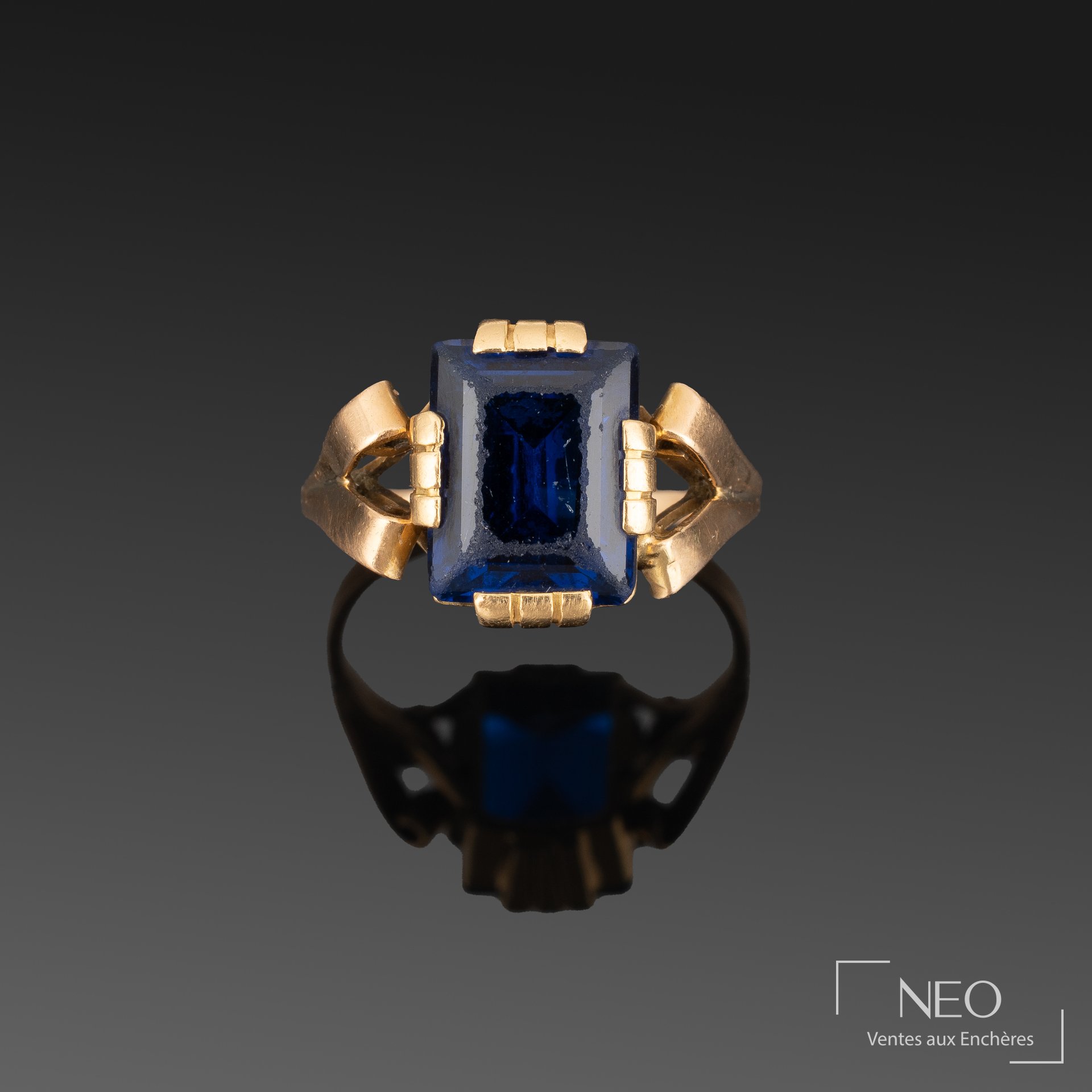 Bague en or jaune avec verre bleu rectangulaire et motifs en volutes