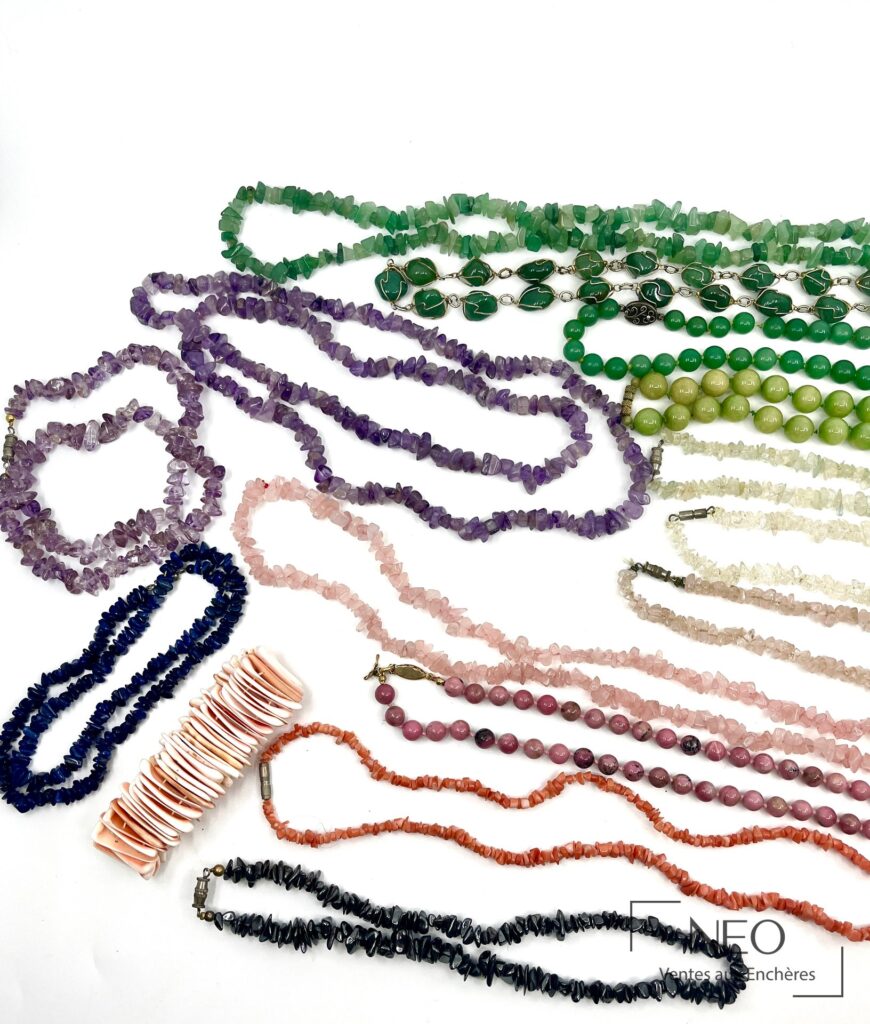Ensemble de colliers et un bracelet en pierres de couleur sur fond blanc