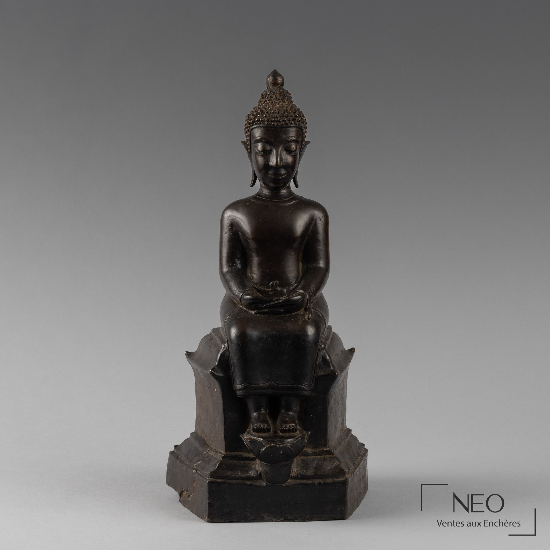 Statue en bronze d'un bouddha assis de face sur son trône pentagonal