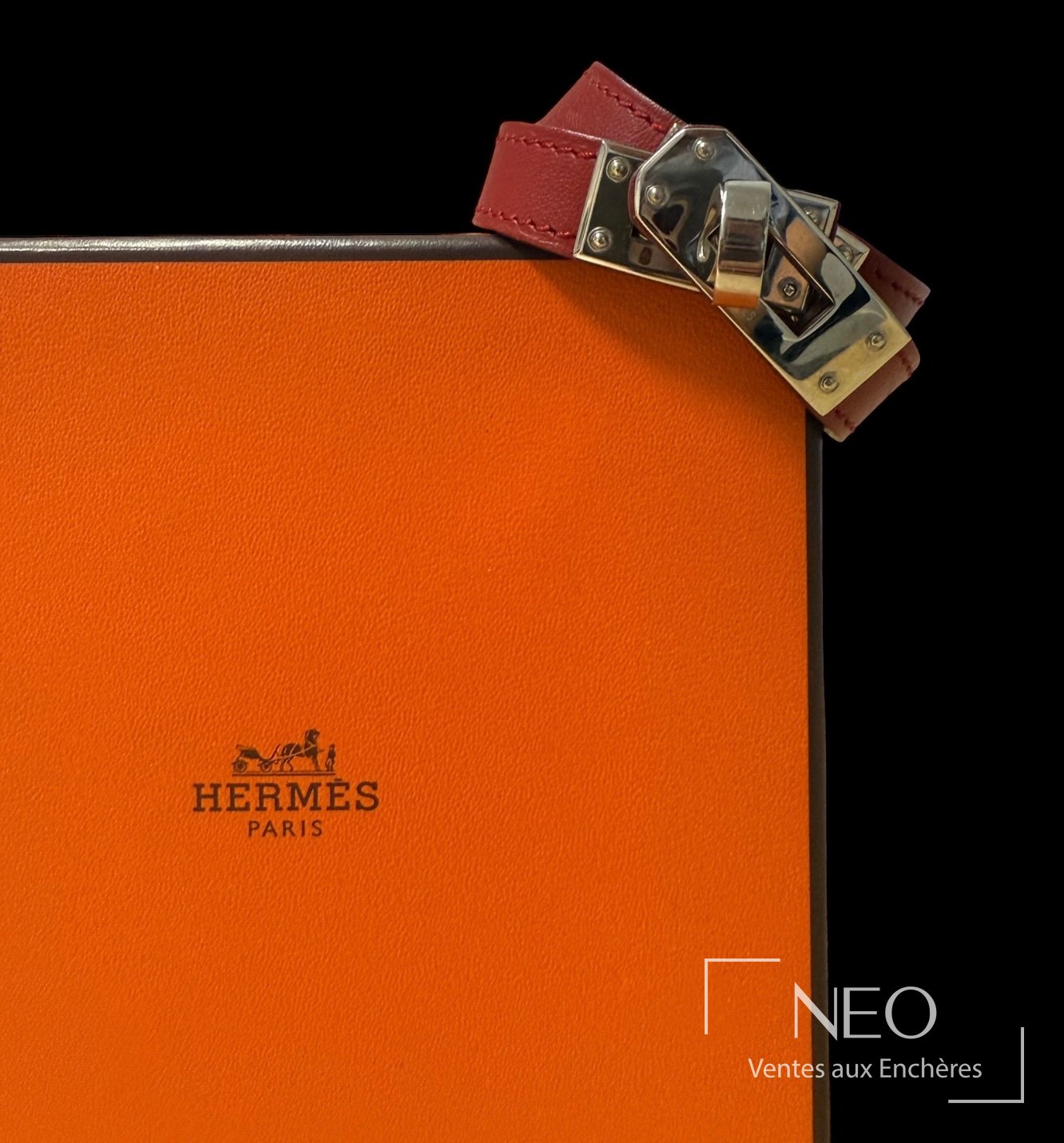 Bracelet Hermès double tour en cuir rouge posé sur son écrin orange