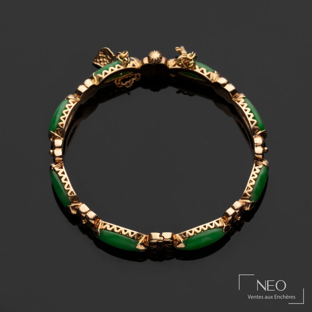 Bracelet jonc en or jaune orné de cabochons verts et de motifs floraux