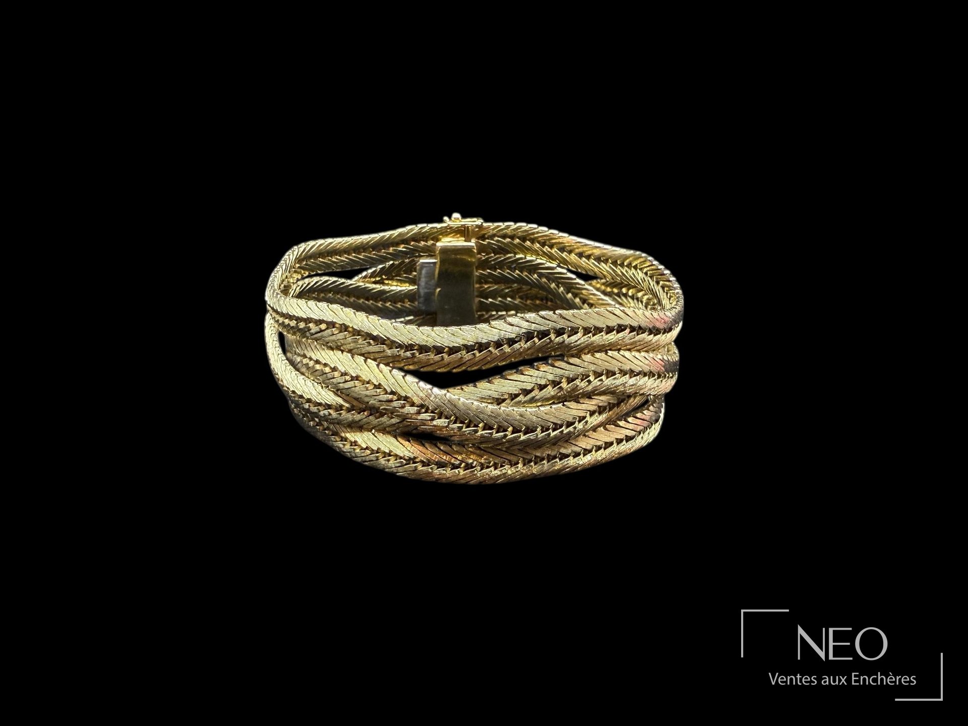 Bracelet en or jaune à maille chevron torsadée sur fond noir