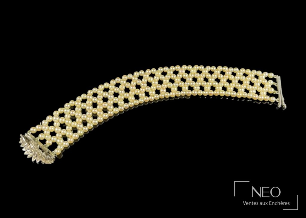 Bracelet ruban en or gris à quatre rangs de perles blanches de culture sur fond noir