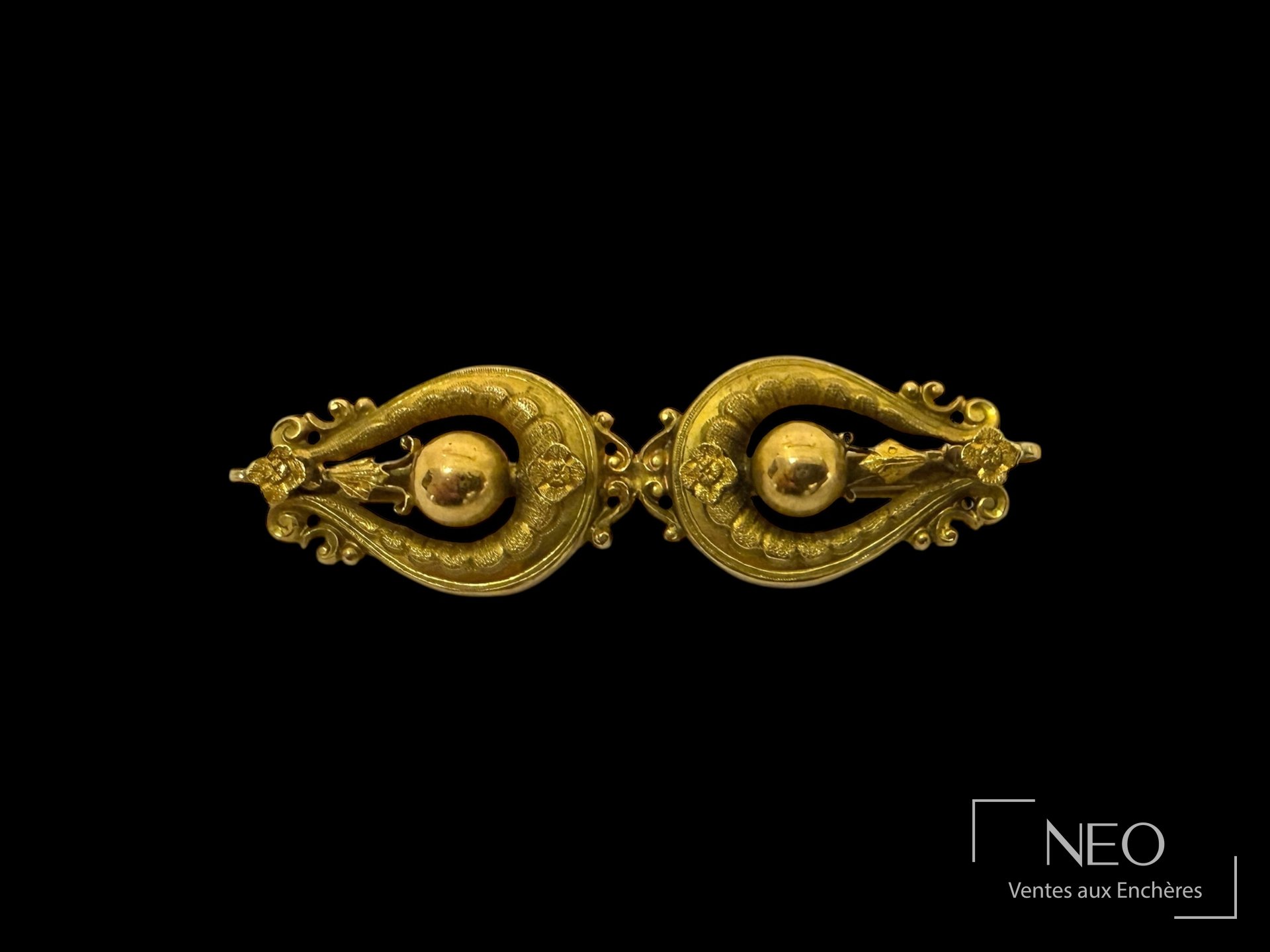 Broche en or jaune 18K stylisant deux éléments violonnés