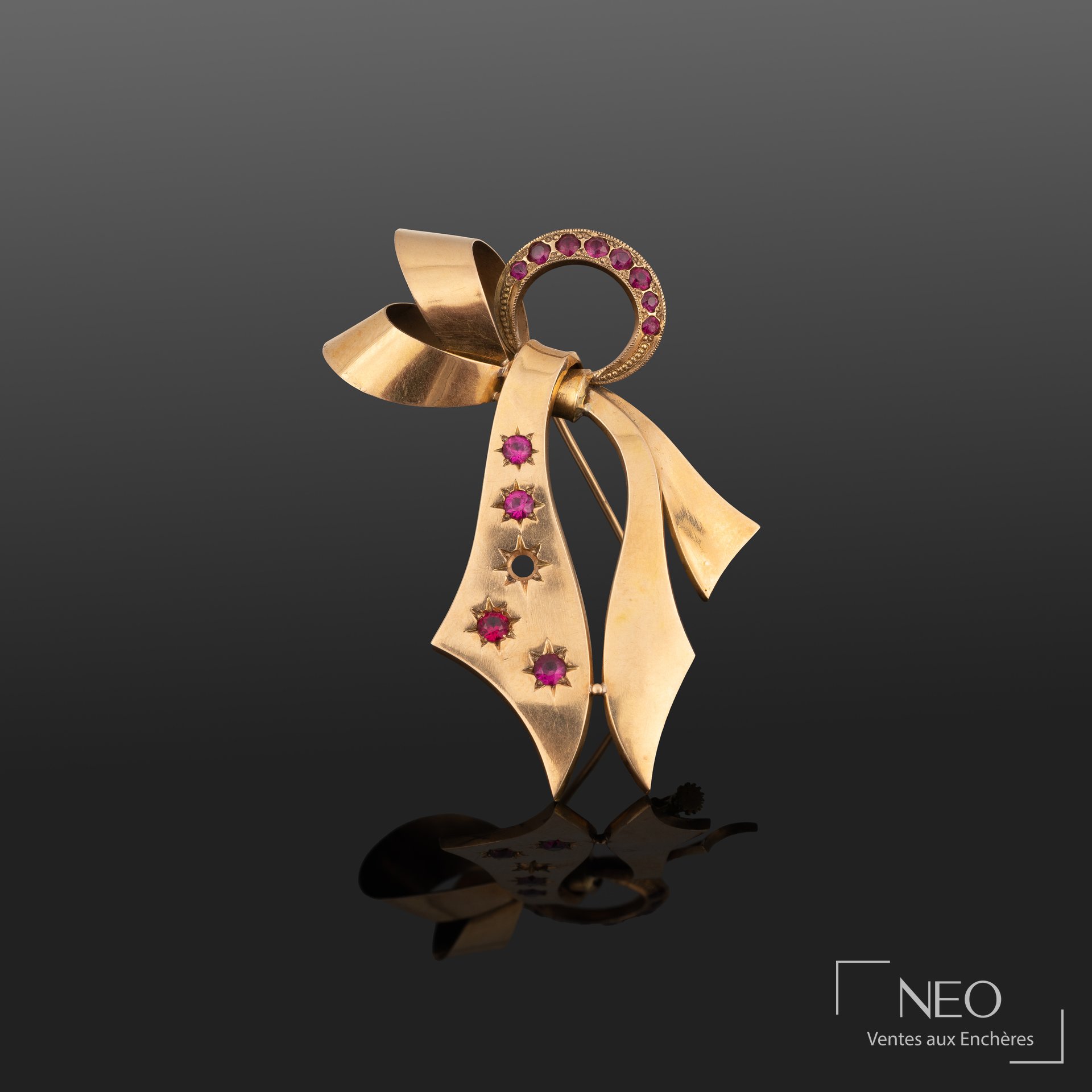 Broche en or jaune 18K ornée de petites pierres rouges facettées