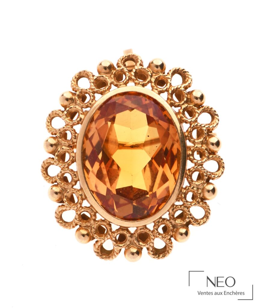 Broche pendentif en or jaune avec pierre ovale jaune-orangée et monture ajourée
