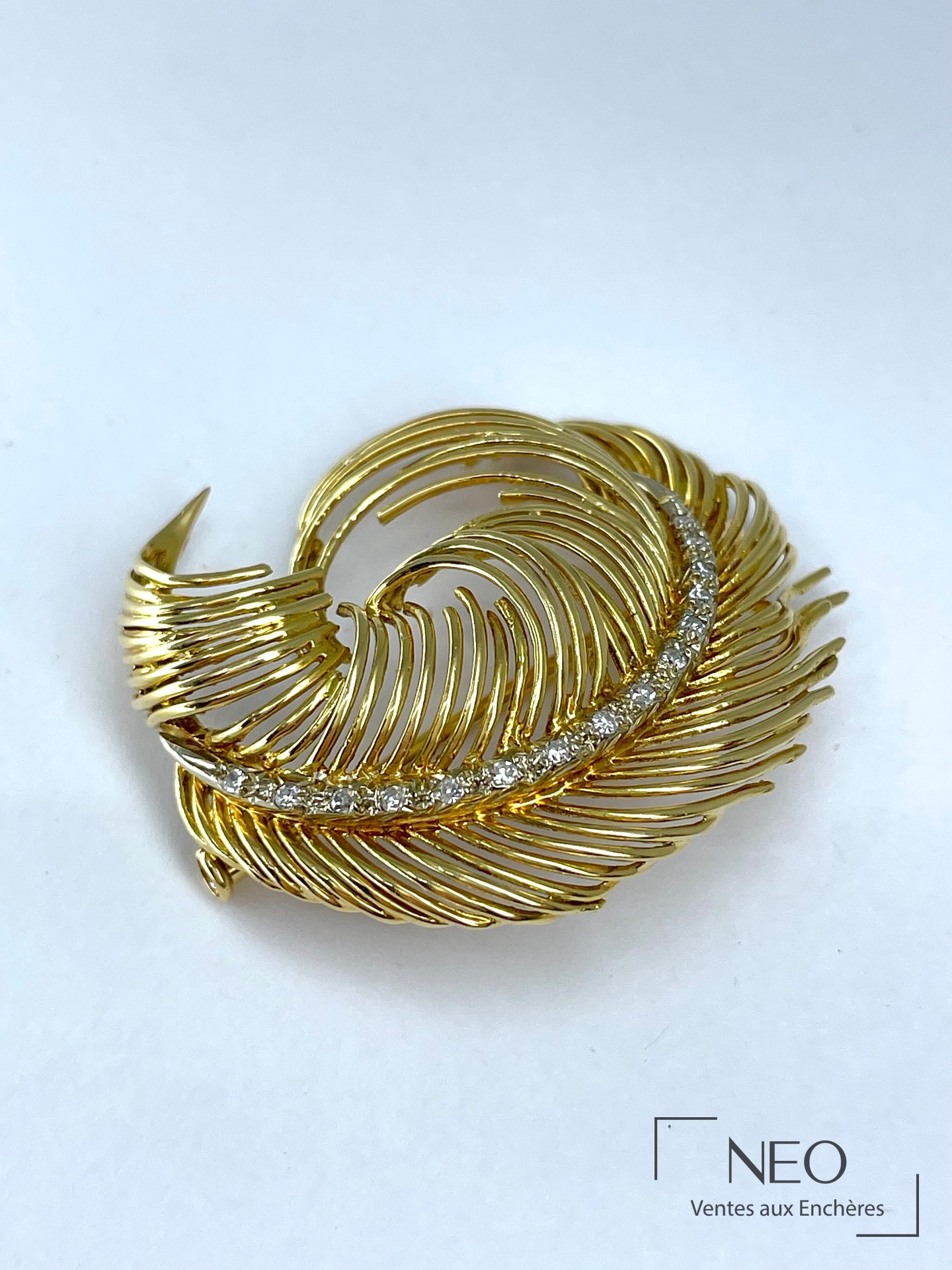 Broche plume en or jaune sertie de diamants sur fond clair