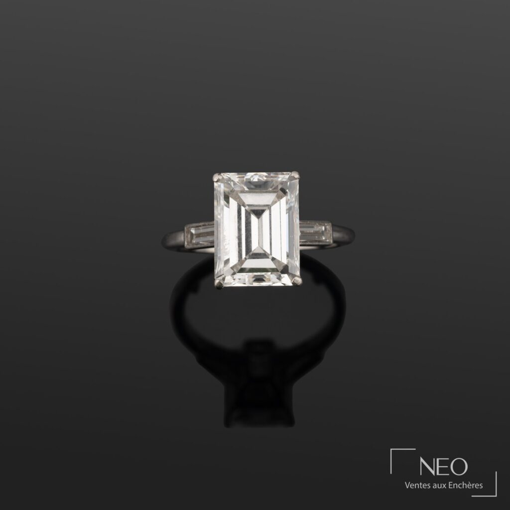 Bague Cartier en platine avec diamant taille émeraude et deux diamants baguettes