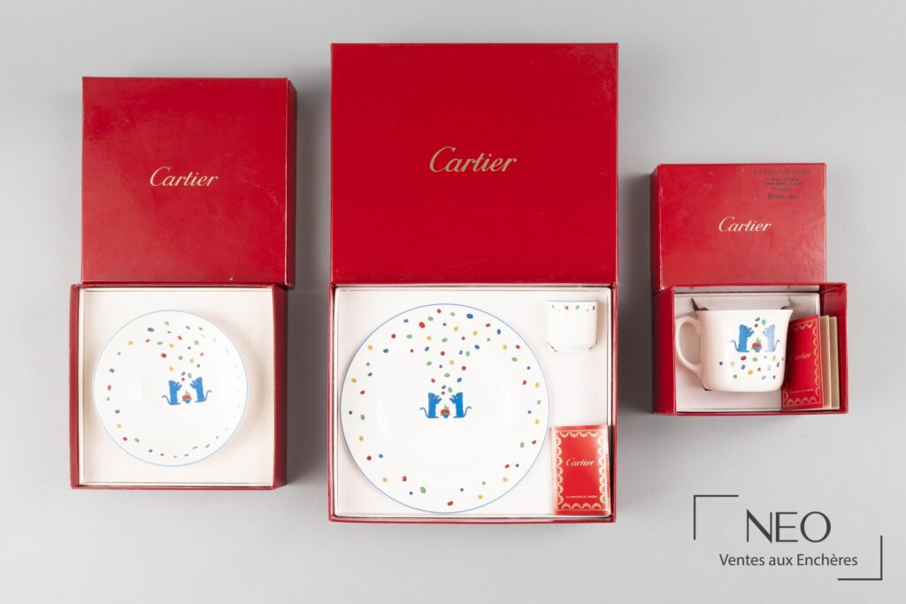 Service Cartier en porcelaine blanche présenté dans ses écrins rouges avec décor polychrome
