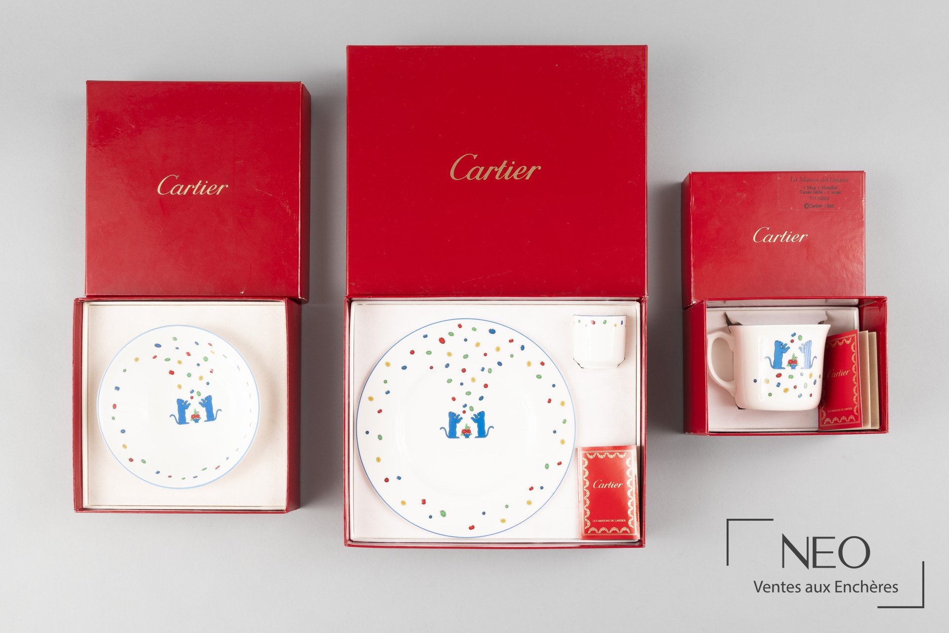 Service Cartier en porcelaine blanche présenté dans ses écrins rouges avec décor polychrome