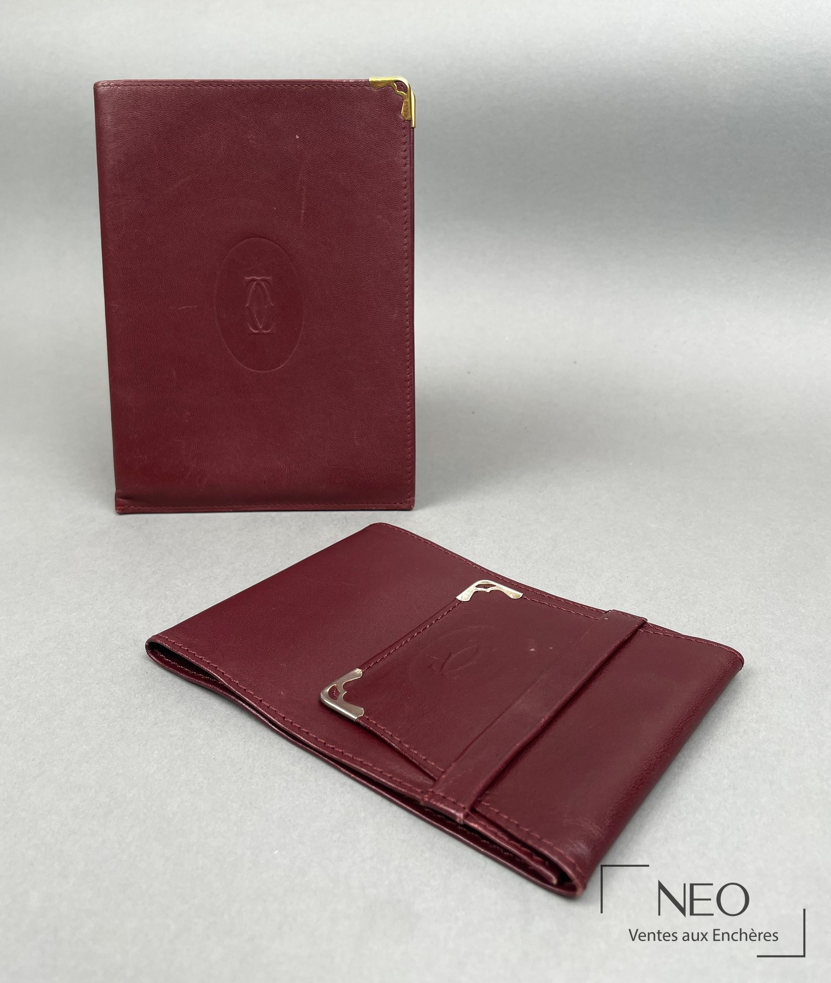 Ensemble Cartier Paris en cuir bordeaux avec porte-chéquier et pochette.
