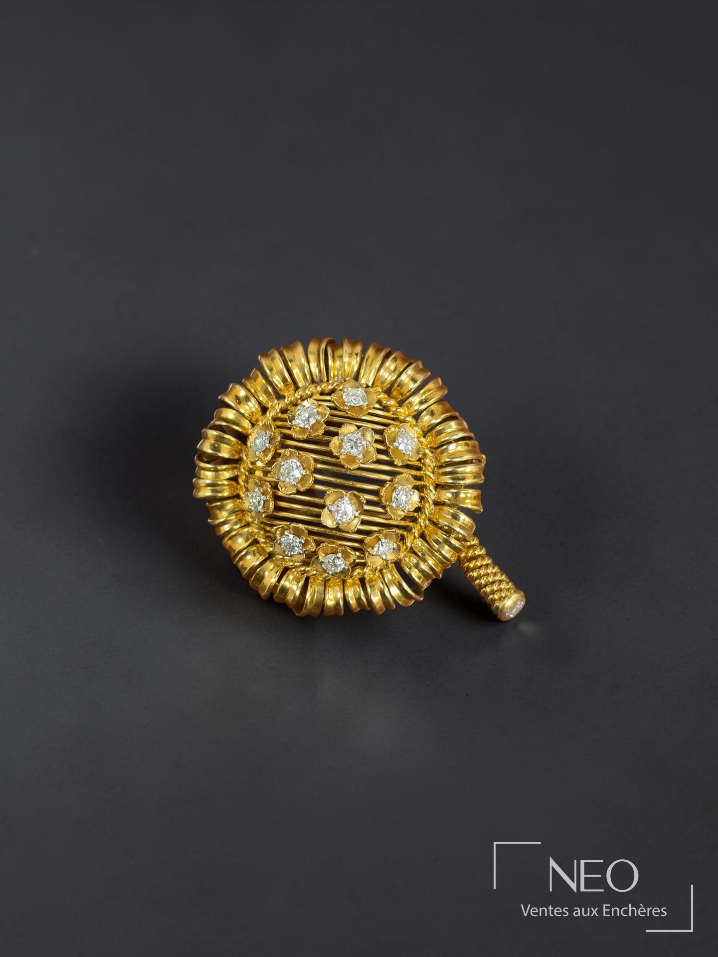 Broche circulaire Cartier Paris en or jaune sertie de diamants sur fond noir