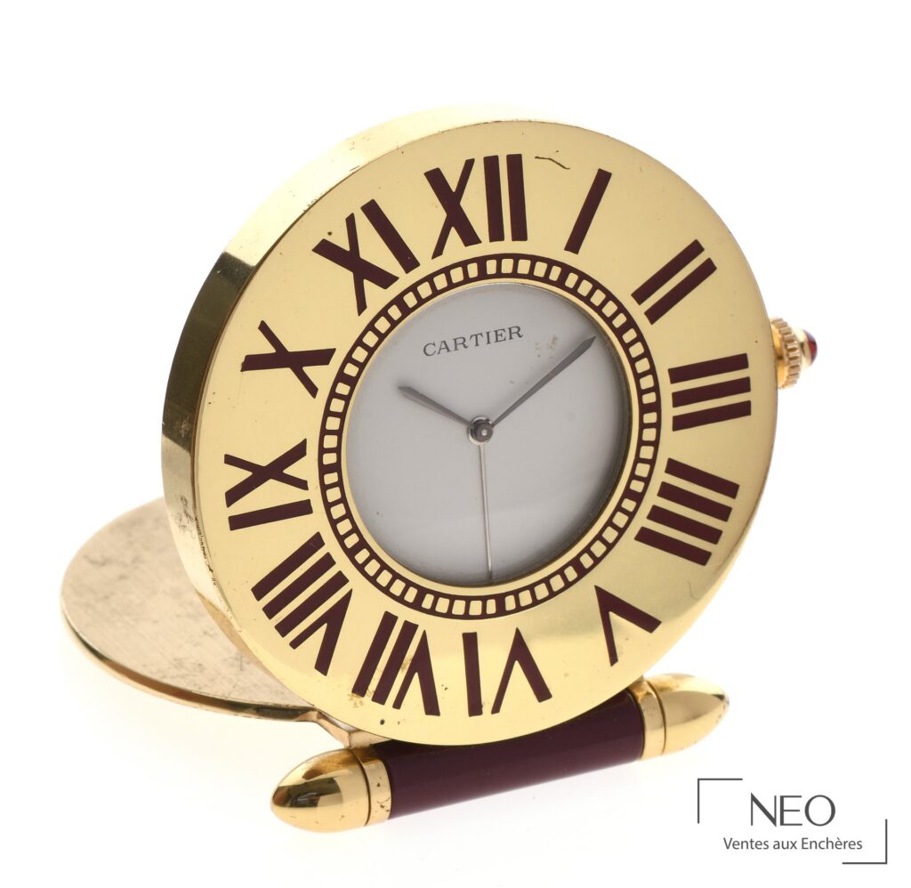 Pendulette Cartier en métal doré avec lunette bordeaux et cadran beige