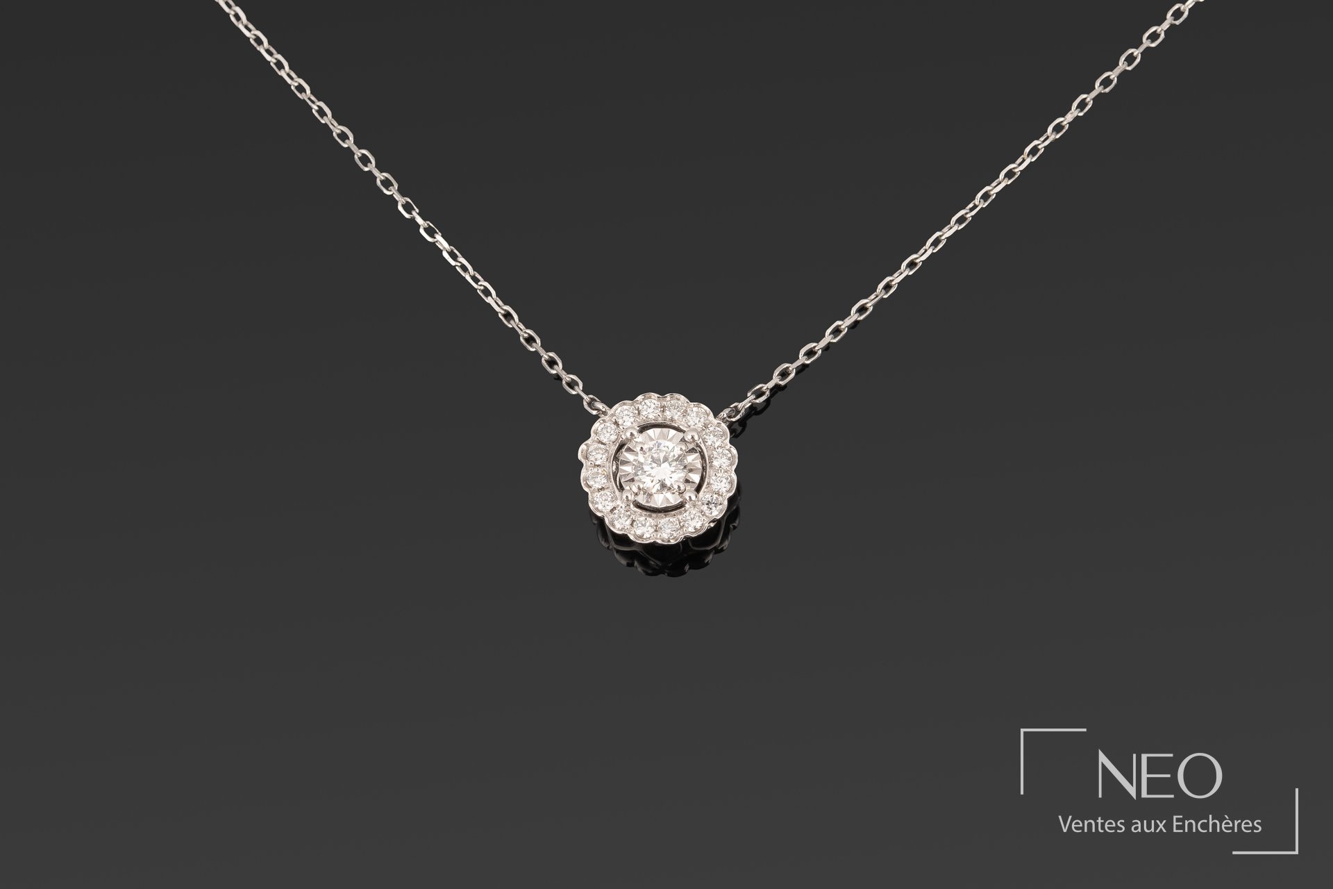 Chaîne de cou en or gris avec pendentif circulaire serti de diamants sur fond sombre