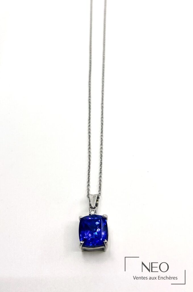 Chaîne de cou en or gris avec pendentif serti d’une tanzanite bleue et d’un petit diamant
