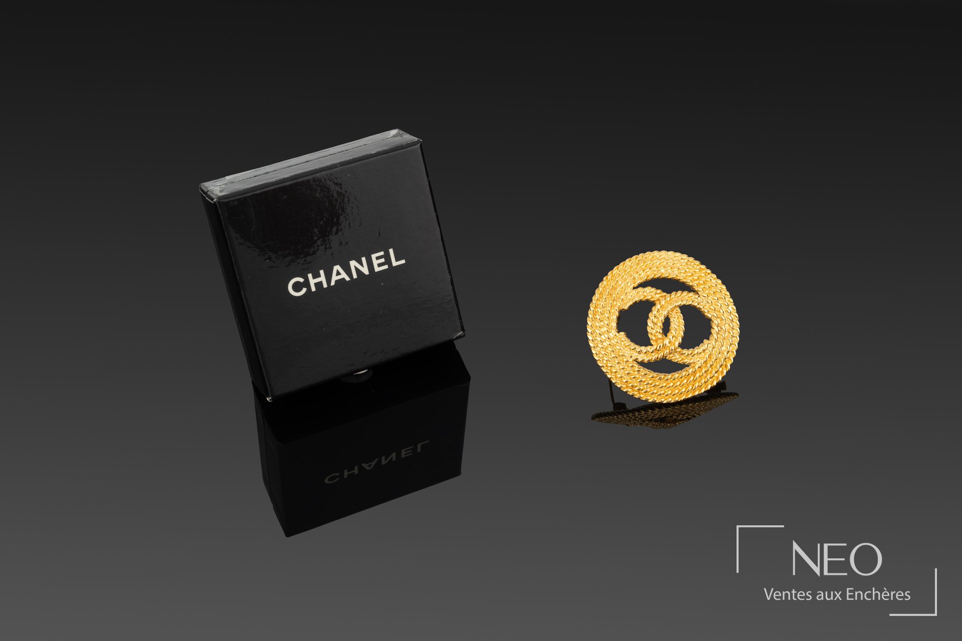 Chanel broche circulaire en métal doré siglé Chanel