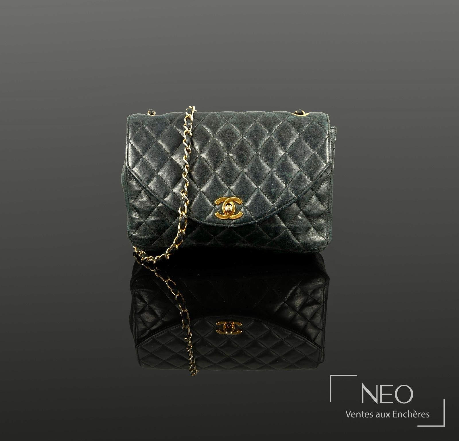 Sac à rabat CHANEL en agneau matelassé bleu marine avec chaîne et logo doré