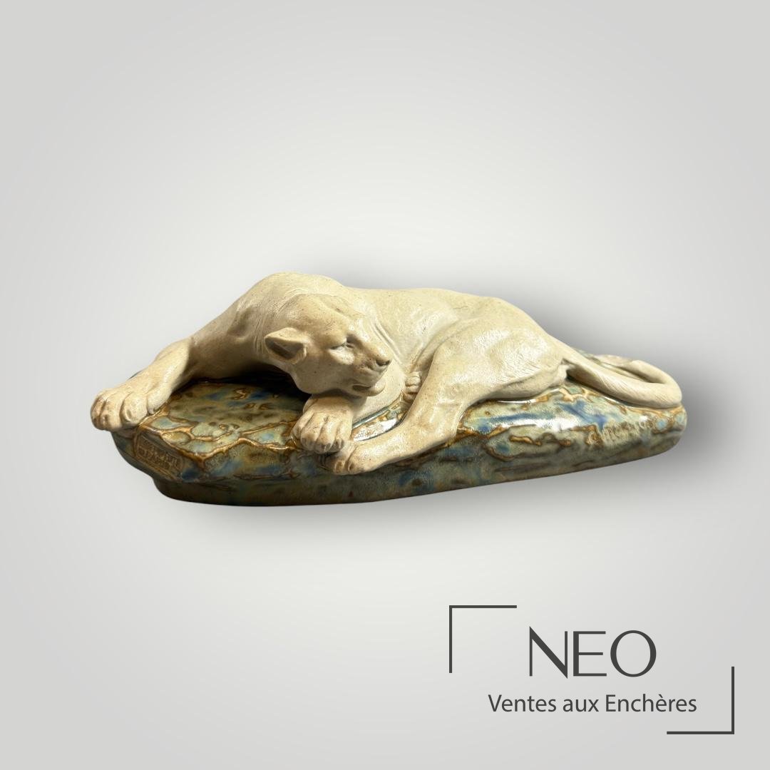 Lionne couchée en grès émaillé sur son socle