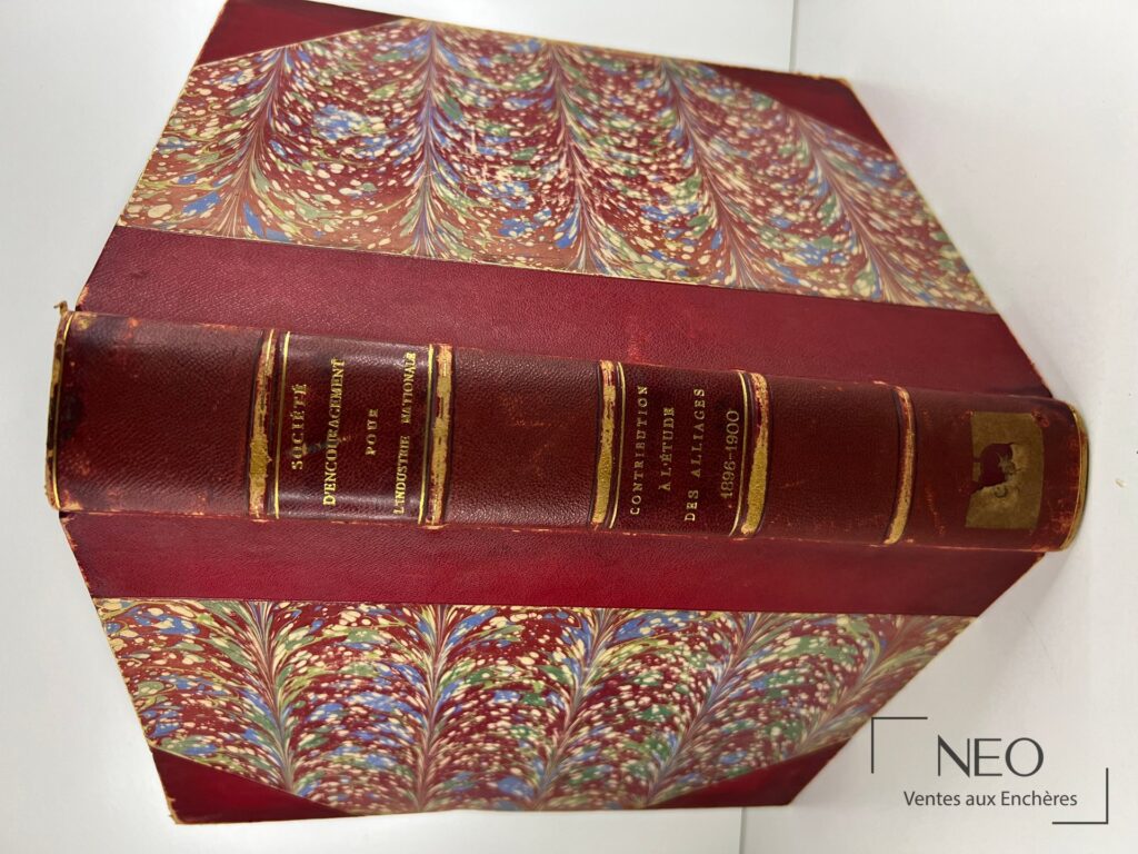 Ouvrage relié en demi chagrin rouge avec plats en papier marbré multicolore et dos doré