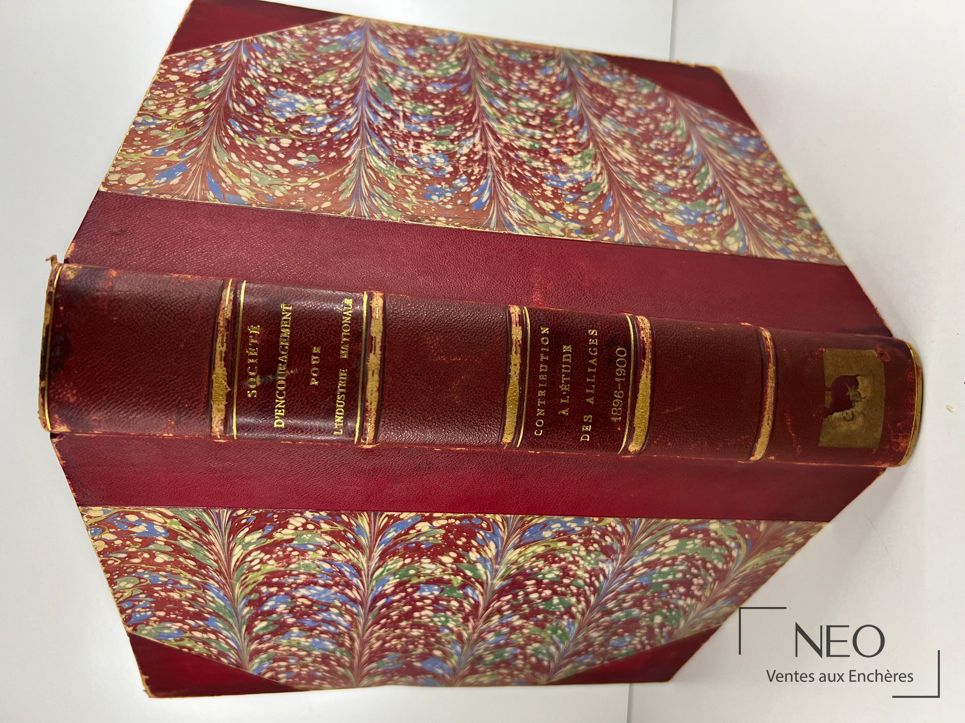 Ouvrage relié en demi chagrin rouge avec plats en papier marbré multicolore et dos doré