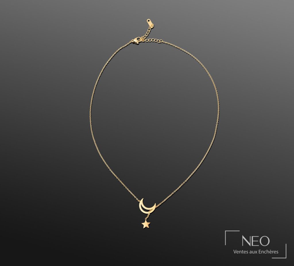 Collier en métal doré avec pendentif lune et étoile sur fond gris