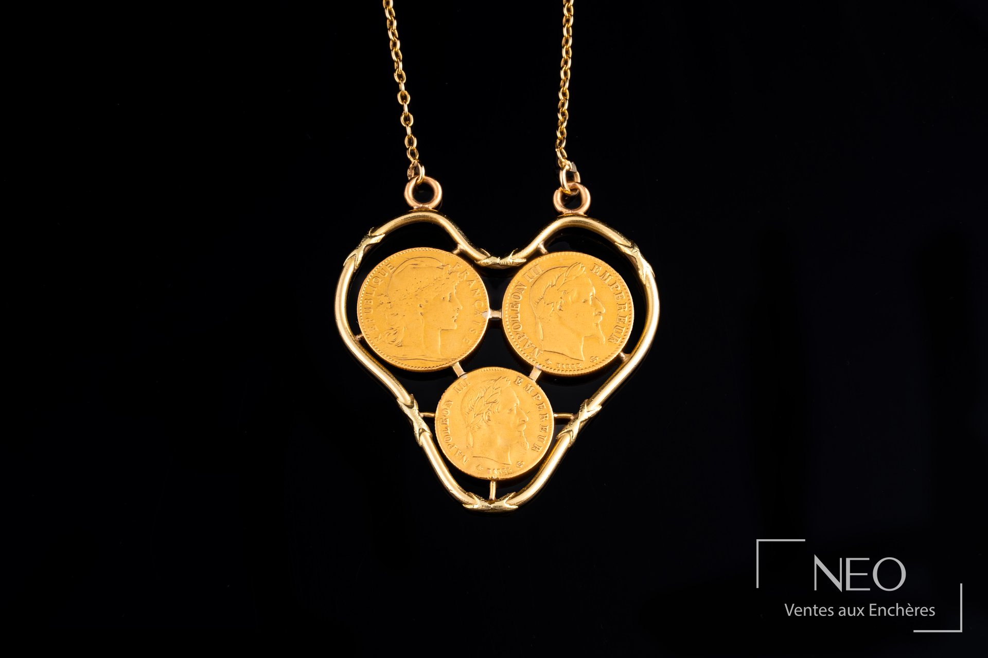 Collier à maille forçat en or jaune 18 carats retenant trois pièces de 10 francs or