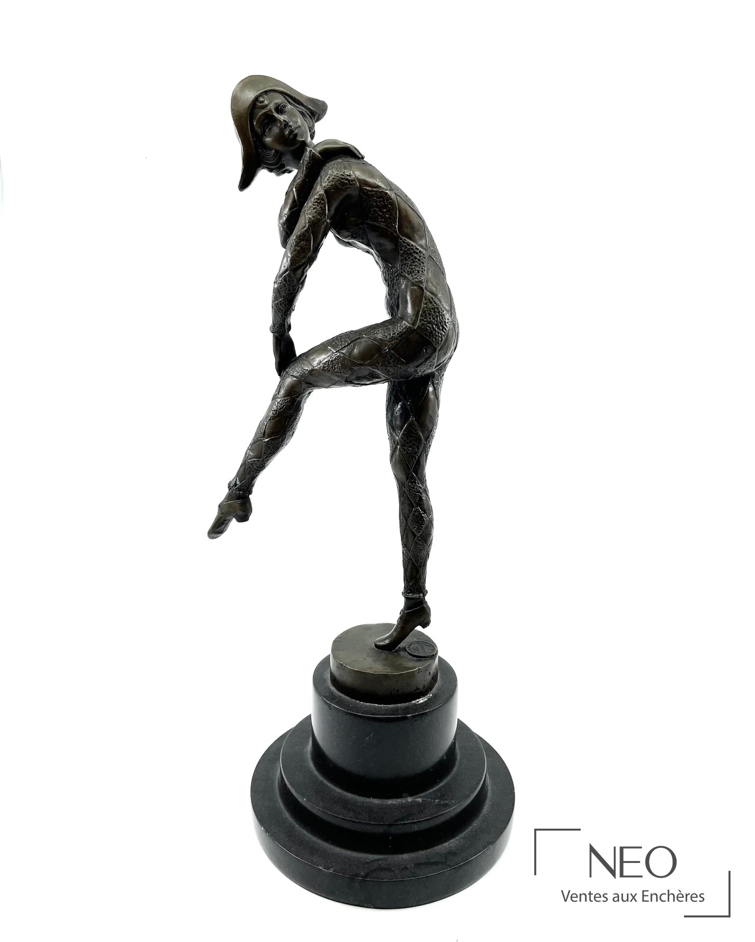 Statuette en bronze patiné représentant Arlequin sur socle circulaire noir