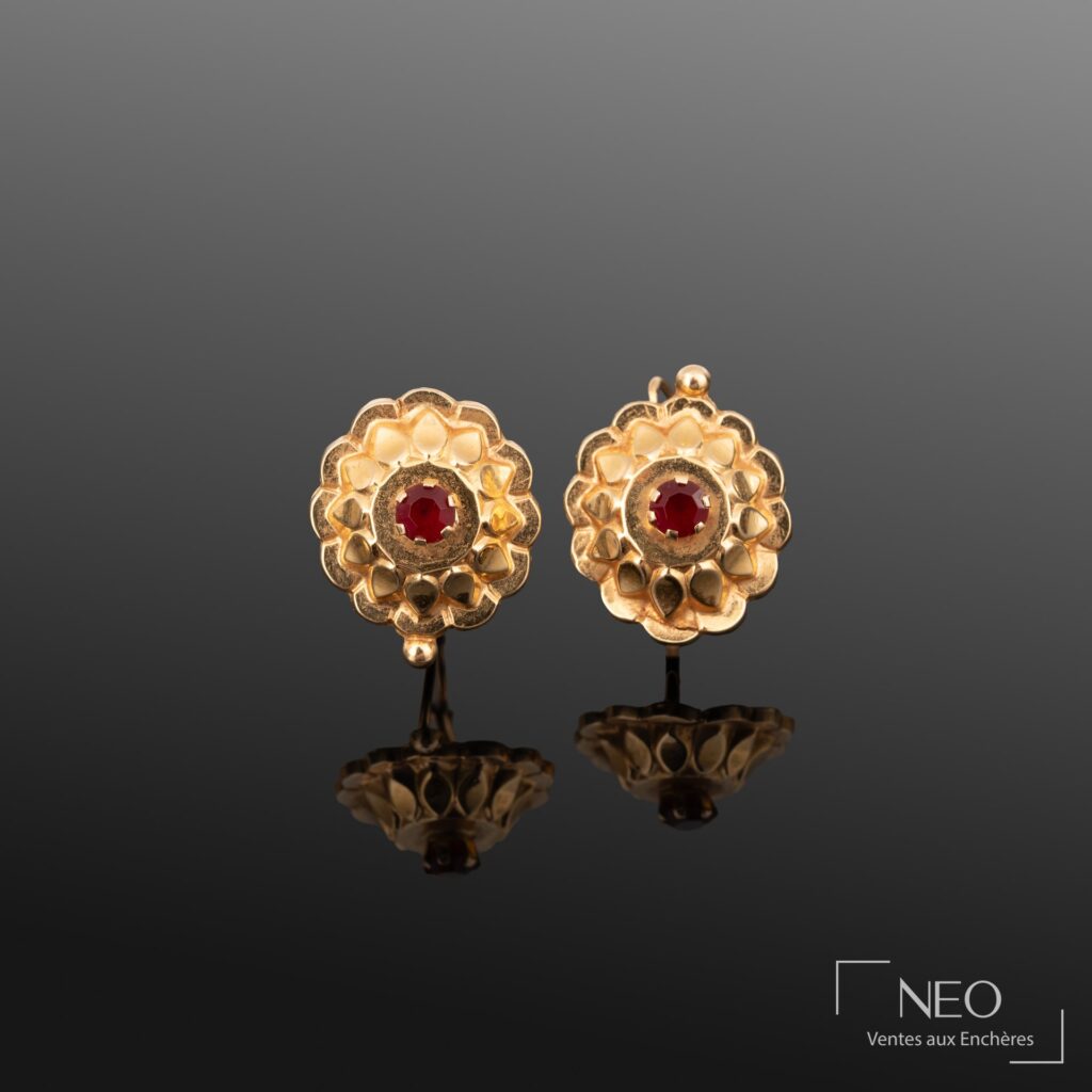 Paire de dormeuses en or jaune à motif de fleur stylisée avec pierre rouge centrale