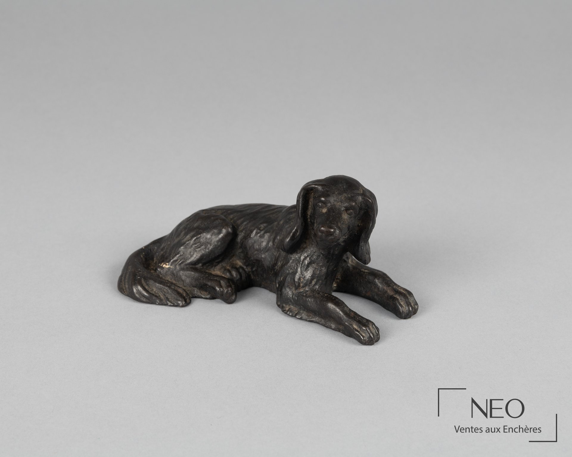 École moderne, chien allongé, épreuve en bronze à patine noire