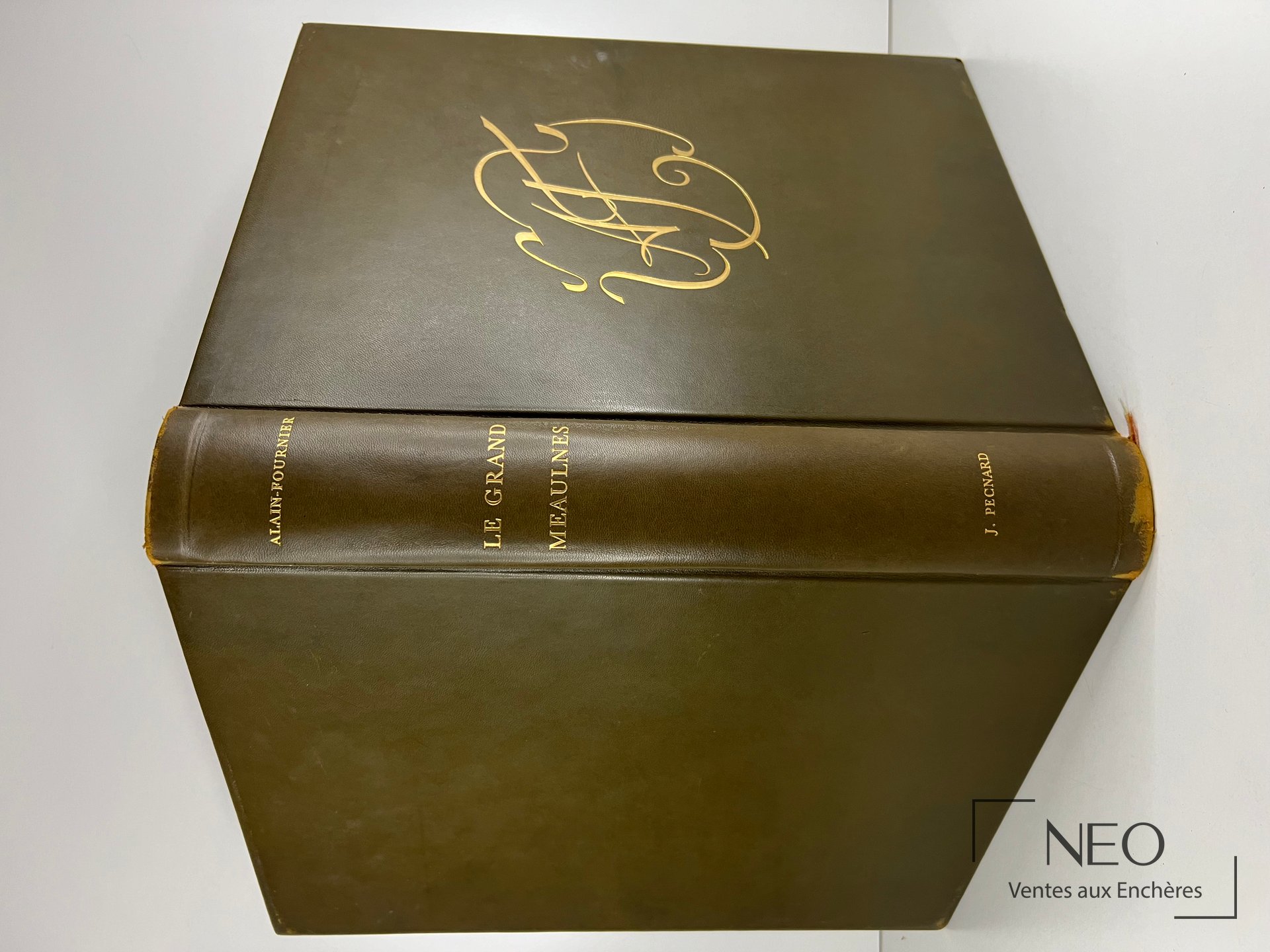 Livre relié en plein cuir brun avec dos doré et titre Le Grand Meaulnes.