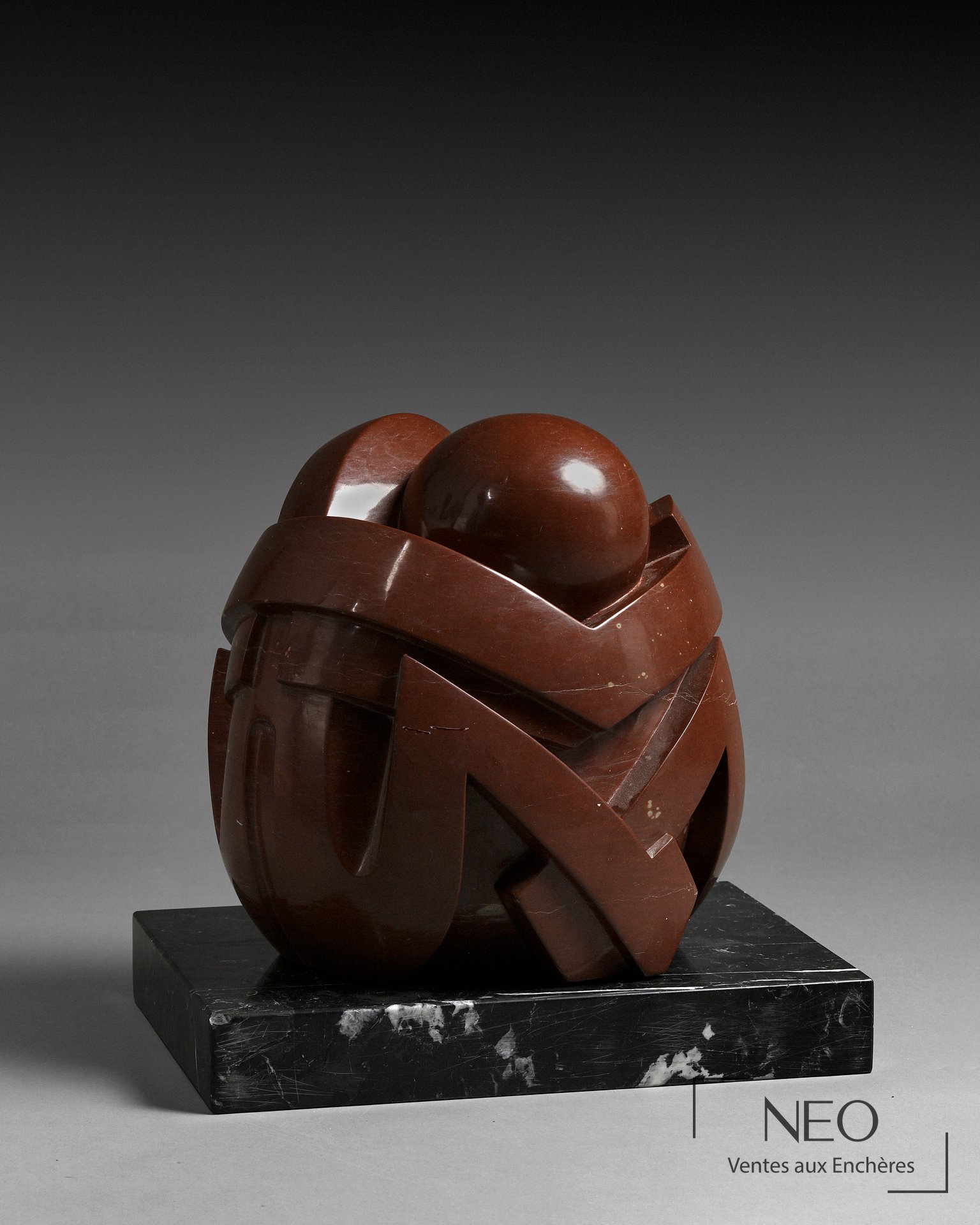 Sculpture abstraite en porphyre rouge sur socle en marbre noir veiné blanc
