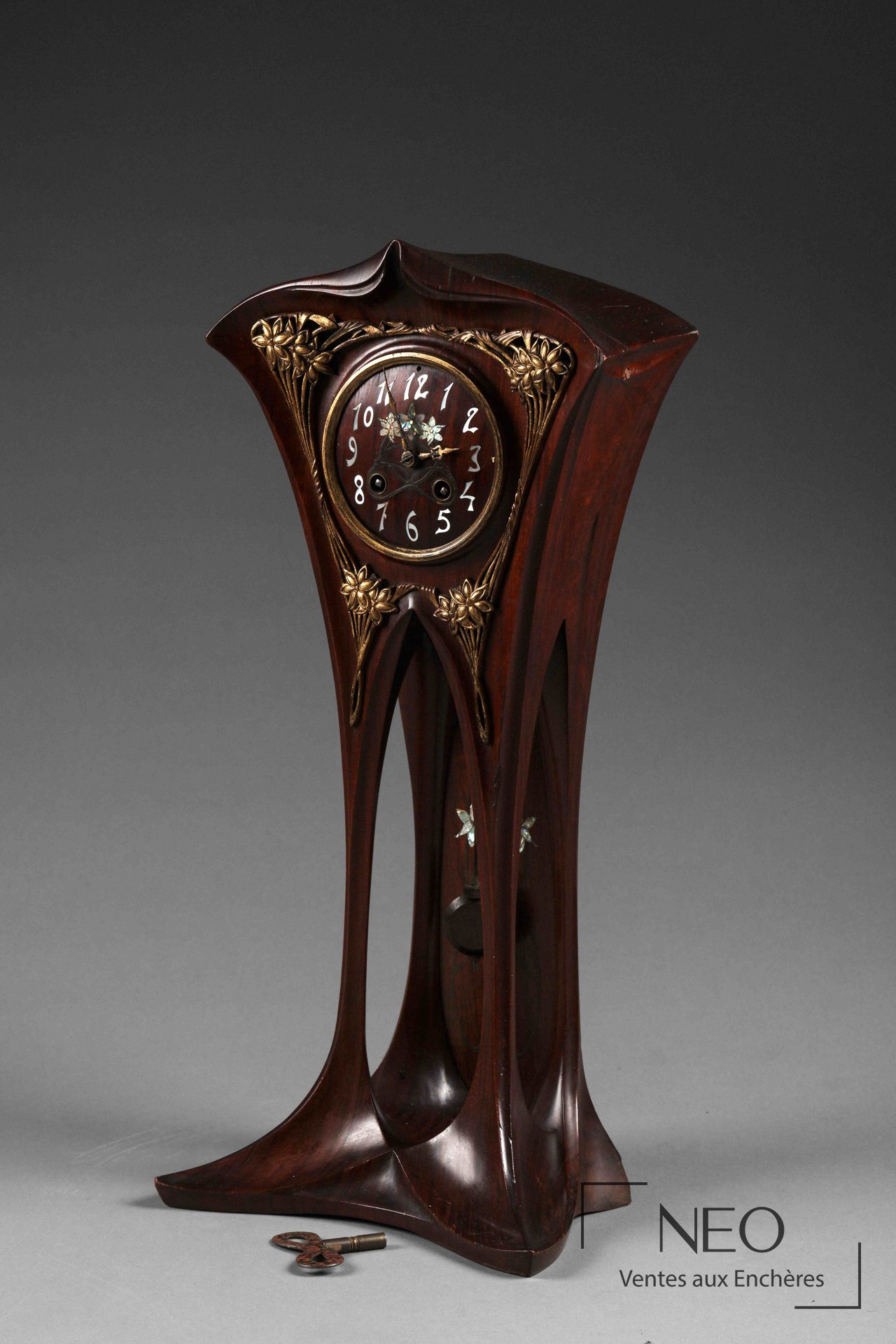 Pendule Art nouveau en bois sculpté avec cadran circulaire et ornements dorés